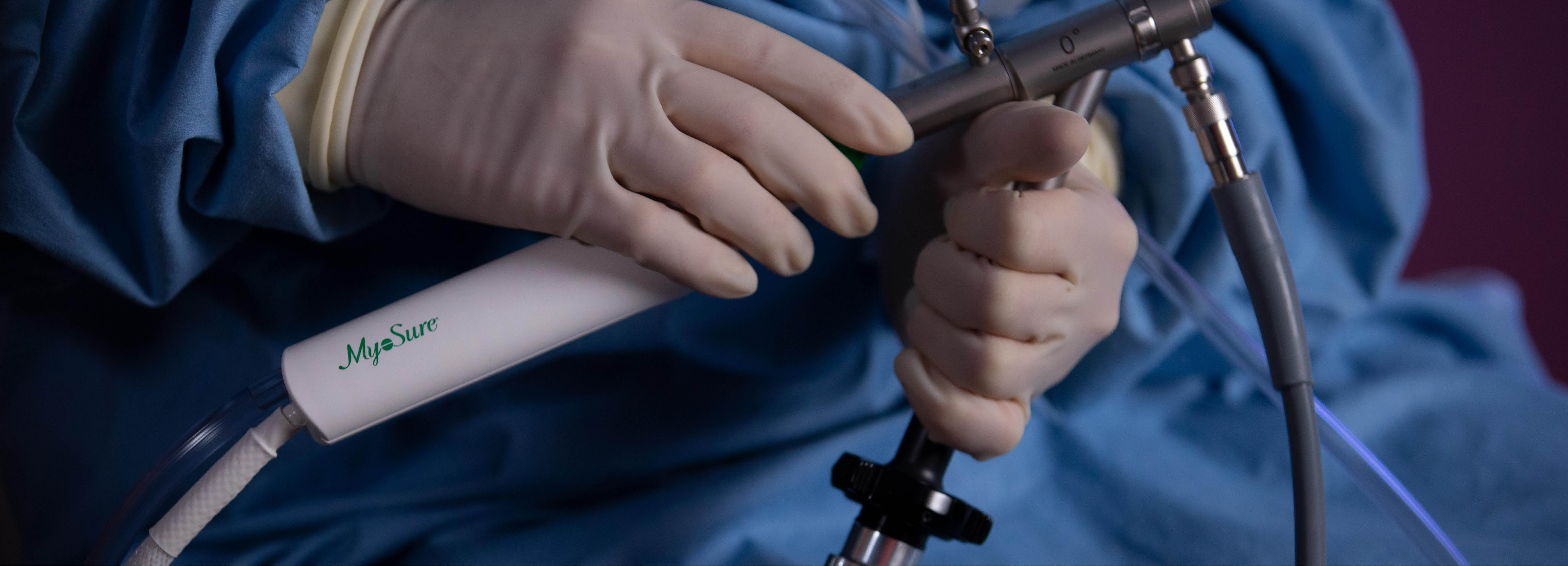 Handskbeklädda händer som håller en medicinteknisk enhet