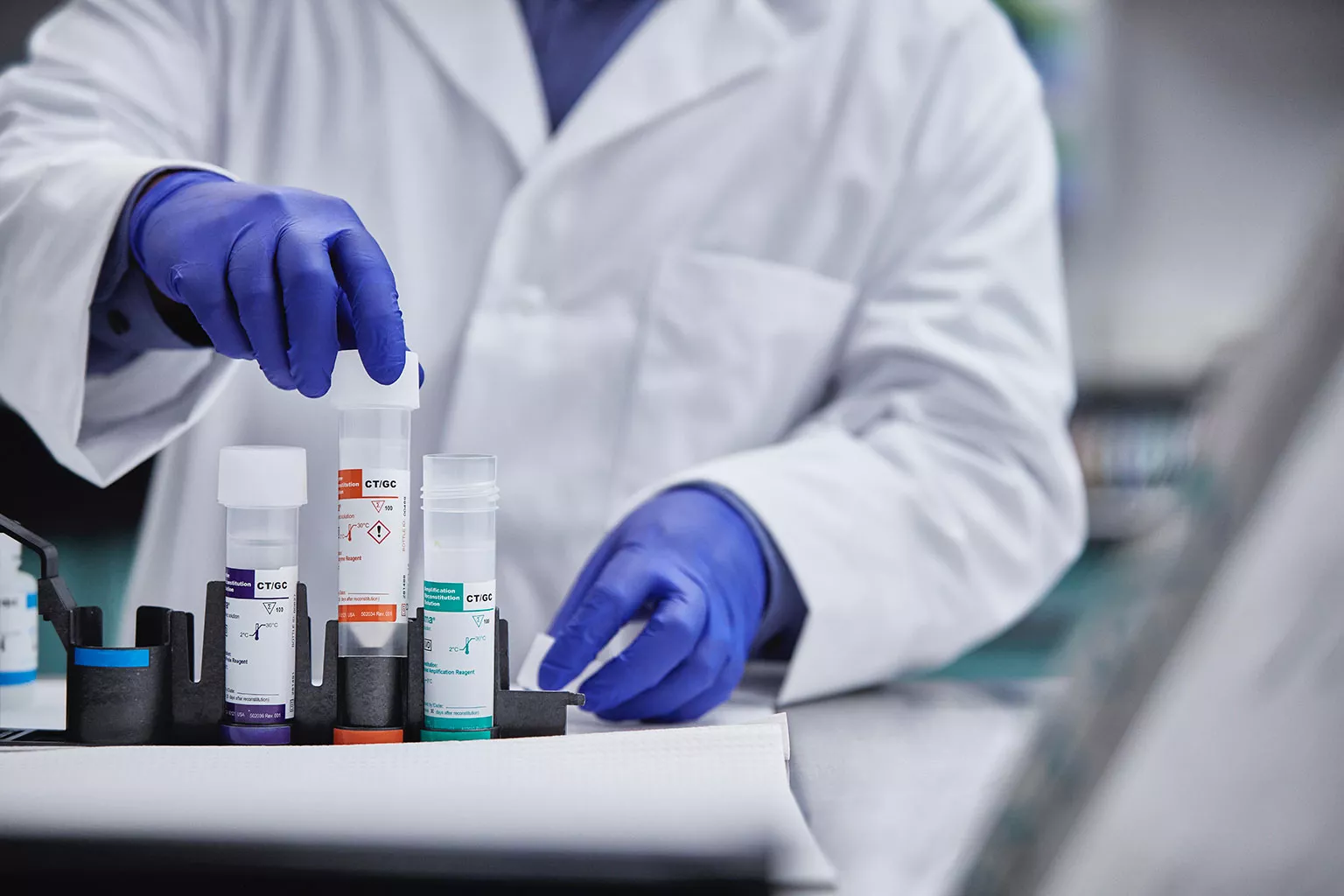 Laboratorietekniker lyfter rör i laboratoriemiljö