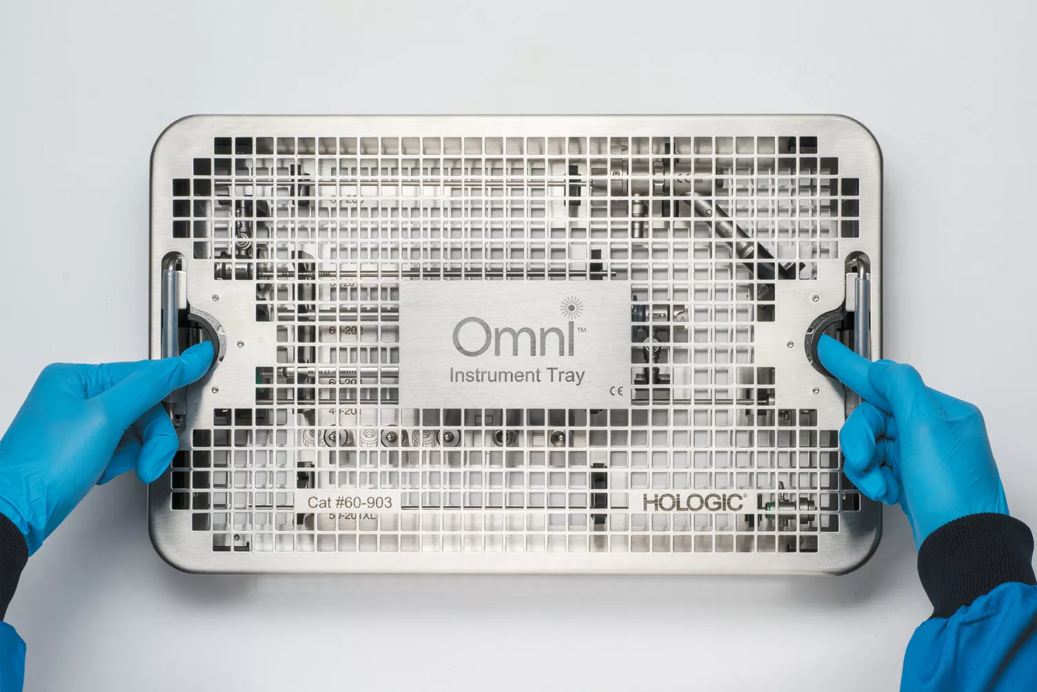 Handskbeklädda händer arbetar med en medicinsk bricka på ett bord.