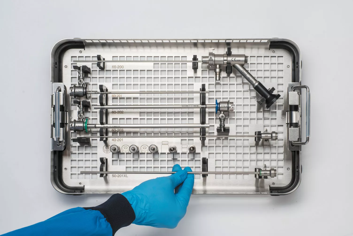 Handskbeklädd hand arbetar med en medicinsk bricka på ett bord.